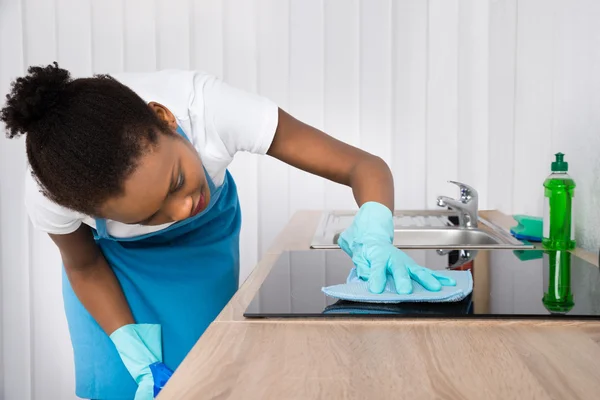 Femmina Janitor pulizia induzione stufa — Foto Stock