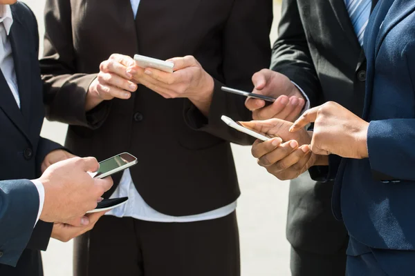 Geschäftsleute greifen zu Mobiltelefonen — Stockfoto