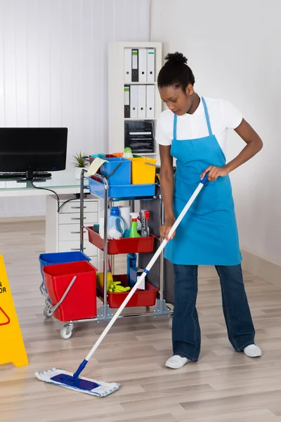 Werkneemster reiniging van de vloer In Office — Stockfoto