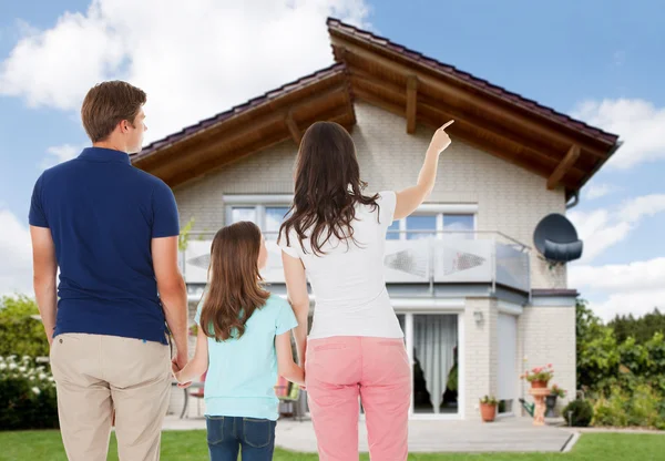 Familie staande voor huis — Stockfoto