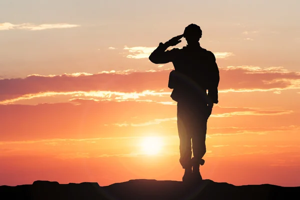 Saudação do soldado durante o pôr do sol — Fotografia de Stock