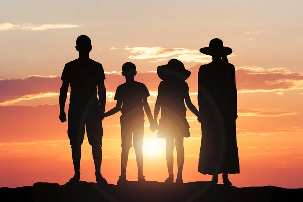 Οικογένεια, κρατώντας τα χέρια μαζί στο ηλιοβασίλεμα — Φωτογραφία Αρχείου