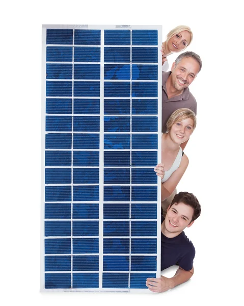 Сім'я надмірно через панель сонячних батарей — стокове фото