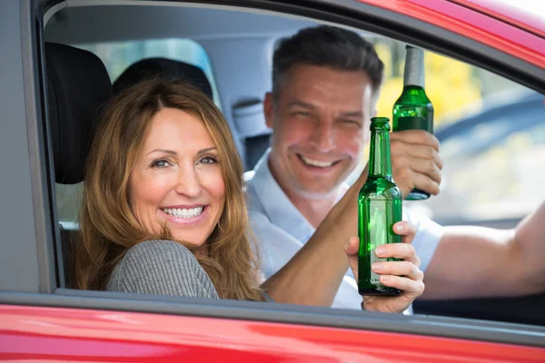 Pareja sentada dentro del coche con cerveza — Foto de Stock