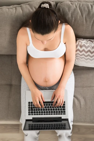 Donna incinta utilizzando il computer portatile — Foto Stock