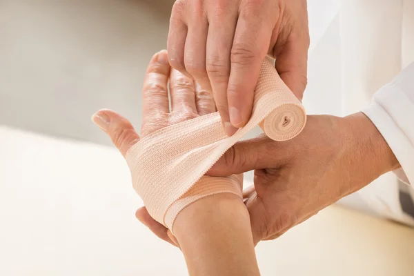 Lekarz Zawijanie elastyczny bandaż do pacjenta — Zdjęcie stockowe