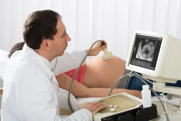 Doctor moviendo transductor de ultrasonido en el vientre — Foto de Stock