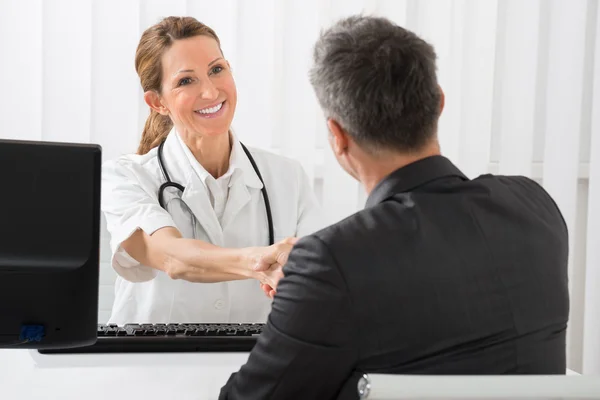 Médico agitando las manos con hombre de negocios — Foto de Stock