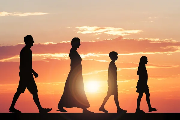 Rodina chůzi proti dramatické obloze — Stock fotografie