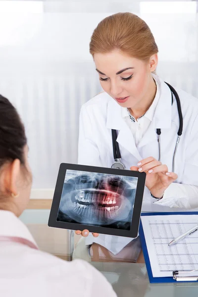 Arzt zeigt Patienten Zähne röntgen — Stockfoto