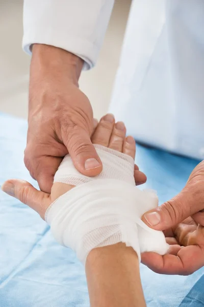 Person wickelt Verband zu Patient — Stockfoto