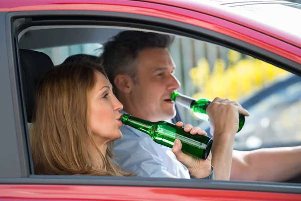 Pareja bebiendo alcohol en coche —  Fotos de Stock