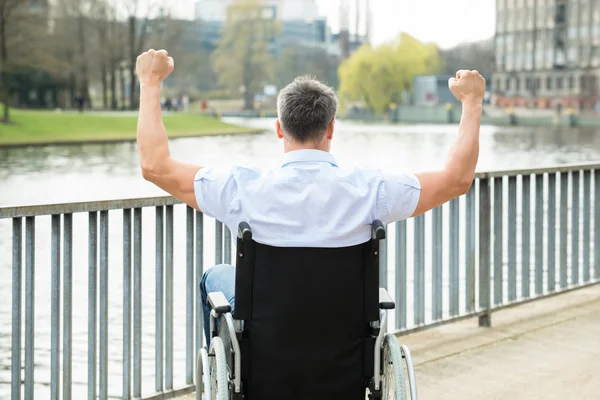 Инвалид на инвалидной коляске с поднятыми руками — стоковое фото