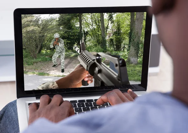 Mann spielt Action-Spiel auf Laptop — Stockfoto