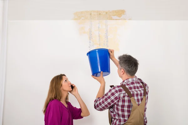 Worker Collecting Water In Bucket From Ceiling — Stock Photo, Image