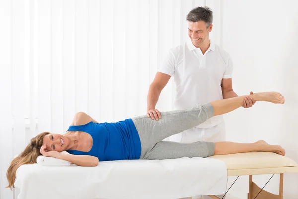 Maschio terapeuta dando gamba massaggio per donna — Foto Stock