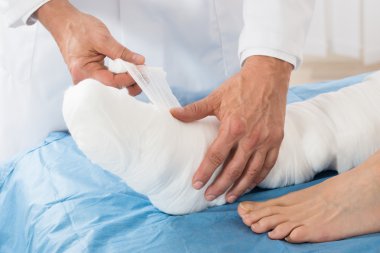 Doktor hastanın bacaklarında bandaj bağlama
