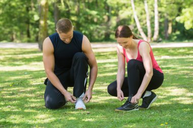 Genç çift ayakkabı bağlama