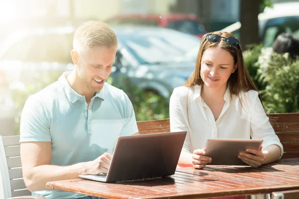 Casal com tablet digital e laptop — Fotografia de Stock