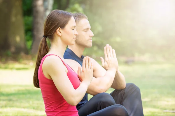 Pareja joven practicando yoga — Foto de Stock