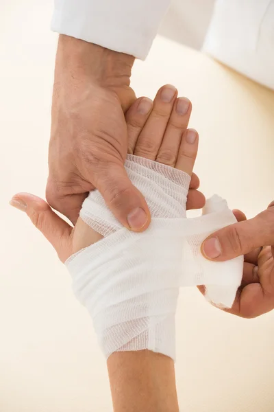 Person wickelt Verband zu Patient — Stockfoto