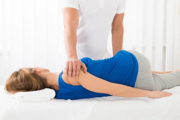 Massagista fazendo massagem na mulher — Fotografia de Stock