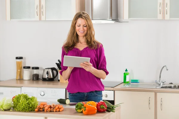 Femme à la recherche de recette sur tablette numérique — Photo