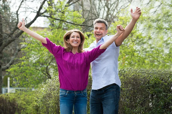 Feliz casal levantando as mãos — Fotografia de Stock