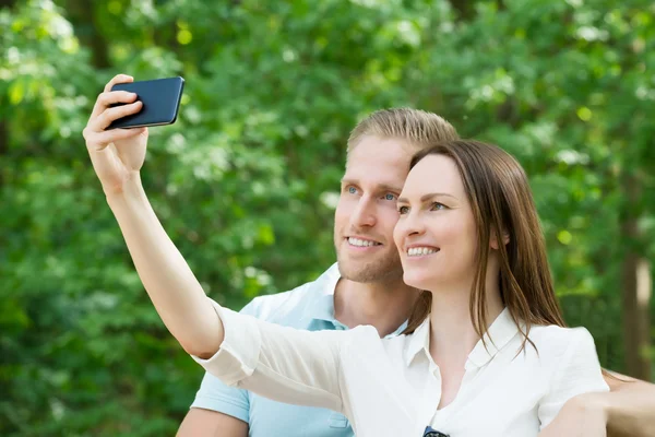 对夫妇与他们的智能手机拍照 — 图库照片