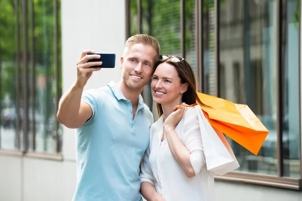 Pár s nákupní tašky vyfotit — Stock fotografie