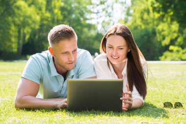 Genç çift dizüstü bilgisayar kullanıyor