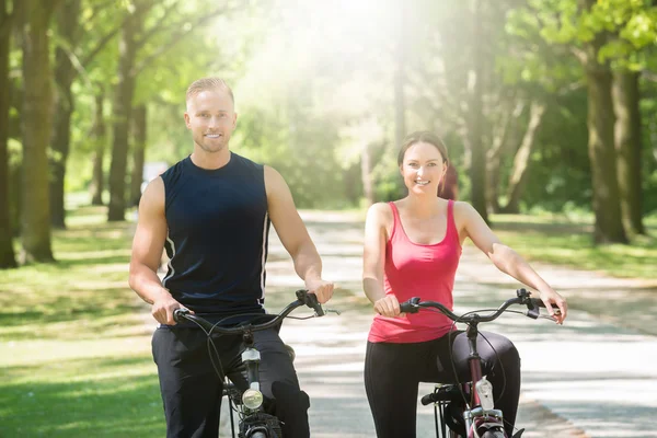 Casal feliz de pé com bicicletas — Fotografia de Stock