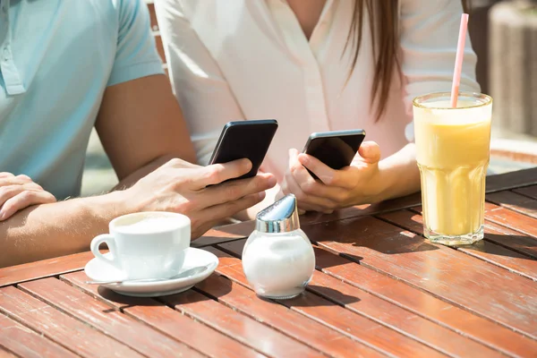 Paar gebruik van mobiele telefoons — Stockfoto