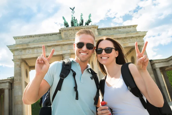 Pareja feliz haciendo señal de paz —  Fotos de Stock