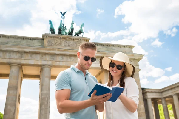 Junges Paar liest Reiseführer — Stockfoto