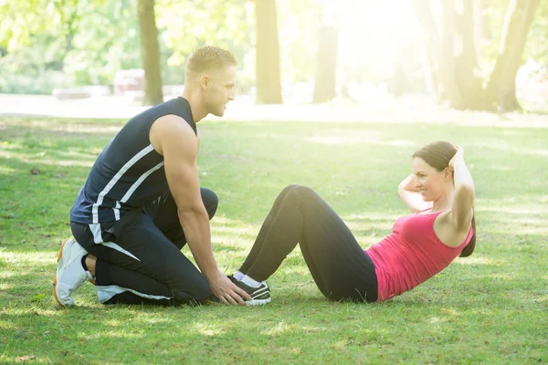 Frau macht Sport mit Hilfe des Mannes — Stockfoto