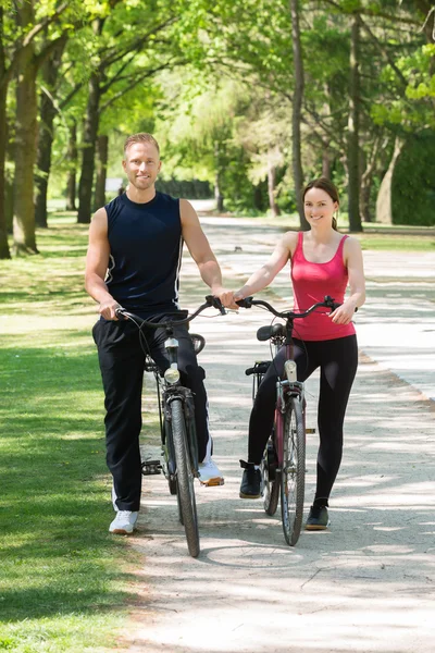 Couple heureux debout avec des vélos — Photo