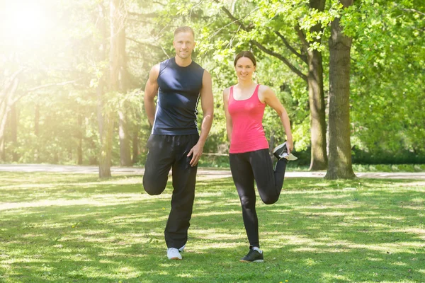 Par som gjør trening i parkering – stockfoto