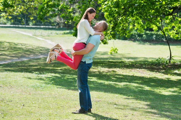 Wanita Lifting Man At Park — Stok Foto