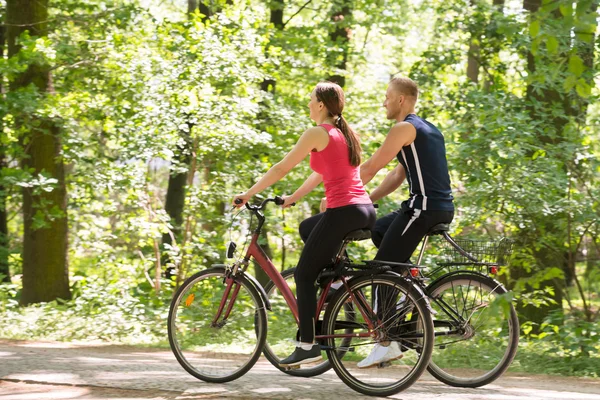 Pareja joven montando bicicletas — Foto de Stock