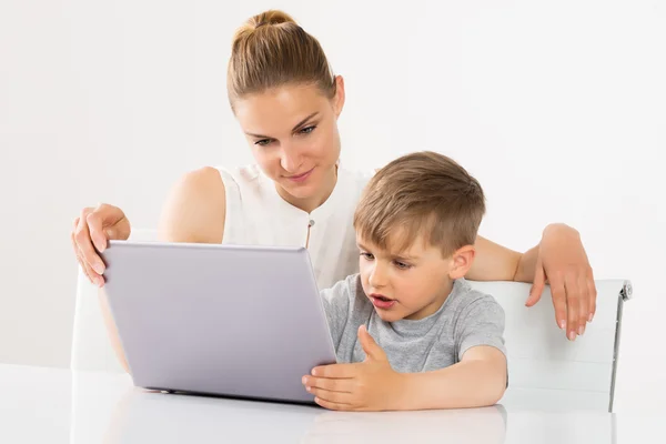 Madre e hijo usando el ordenador portátil — Foto de Stock