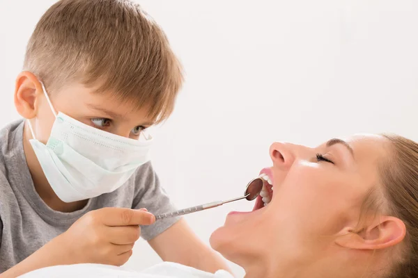 Niño examinando los dientes de la mujer — Foto de Stock