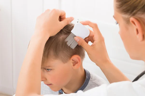 Médico fazendo tratamento no cabelo do menino — Fotografia de Stock