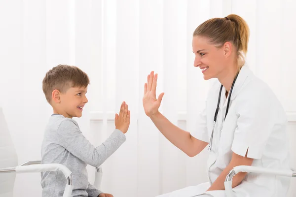 Läkare ger High Five till pojke — Stockfoto
