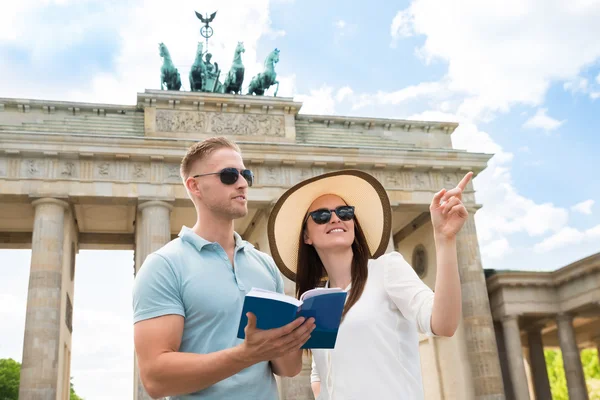 Junges Paar liest Reiseführer — Stockfoto