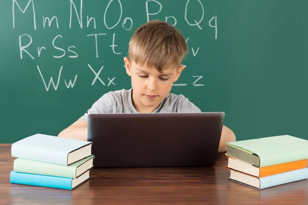 Menino usando laptop na escola — Fotografia de Stock