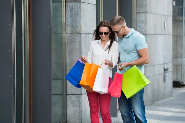 Pareja joven con bolsas de compras — Foto de Stock