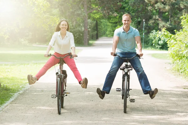 Feliz casal equitação bicicleta no parque — Fotografia de Stock