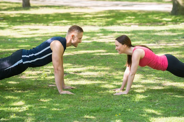 Couple Doing Push-ups In Park — Stock Photo, Image