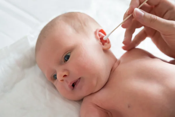 Mãe limpeza orelha do bebê — Fotografia de Stock